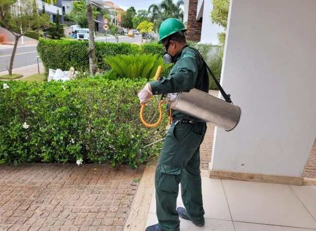 Técnico da Detecta pulverizando a área externa de uma casa